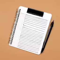 a notebook with lined paper and a pen on the cover