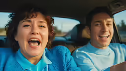 two people, one with an amazed look, are in a car