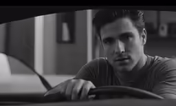 man in grey shirt driving down the street while wearing a headpiece