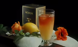 a glass filled with liquid next to a book