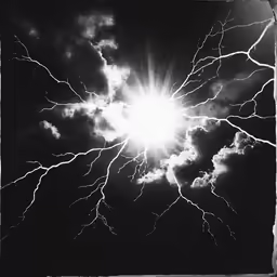 a black and white photo with the sun bursting from it