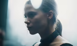 a woman in black and wearing a long ponytail