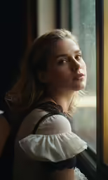 young beautiful woman looking out the window and smiling