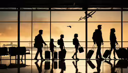 people walking past a window looking at an airplane in the sky,people walking past an airport window with their luggage