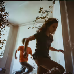 two people in a window with a kid running next to them