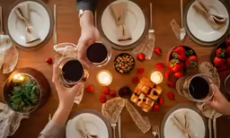 an overhead view of two people holding their glasses up to each other