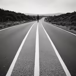 a lone man stands on an empty road