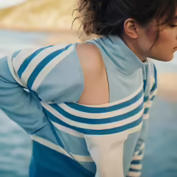 a close up of a woman standing near a body of water