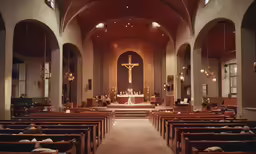 a church that has a crucifix and candles inside of it