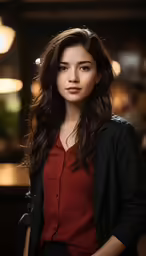 a young woman in a dark room with her hands in her pockets