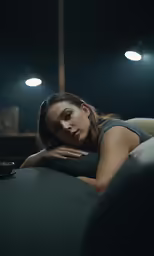 a woman laying on a bed with her head resting against her pillow