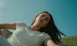 young woman with long dark hair laying on the grass