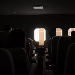 a room with many chairs and bright light coming through the windows