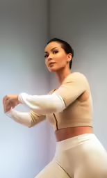 a woman with a top and tights is posing