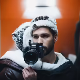 a man that is holding a camera in his hand