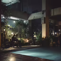 people sitting in an open room at night
