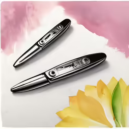 three different metal pens on top of a flower