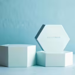two geometric white boxes with the lids open