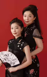 two asian women posing for a portrait while holding each other,two woman dressed in asian fashion are posing together