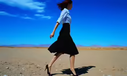 a girl with long dark hair is walking in a desert