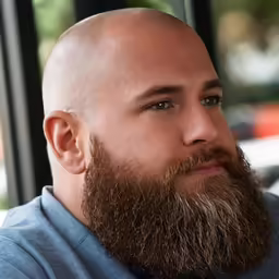 a close up of a bald man with a shaved beard