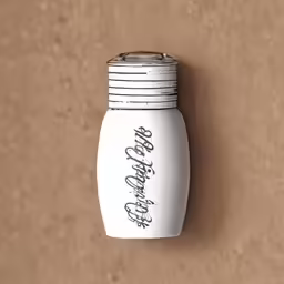 an antique white bottle is hanging on a cork board