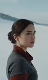 a woman wearing a cardigan looking off into the distance