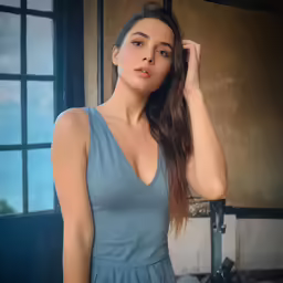 a woman that is standing in a room with a dress