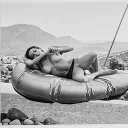 a black and white photo of a woman in bikini on a beach