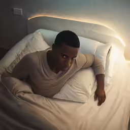 a man laying down on a pillow in a bed