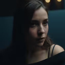 a woman with long hair is sitting down
