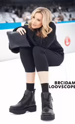 a woman in black knee high boots and black jacket sitting on a ice rink