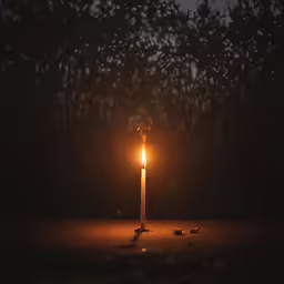a lit candle on a floor and in the foreground