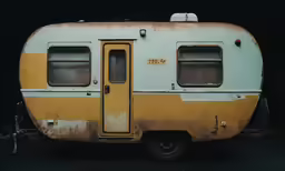 an old yellow and grey trailer sitting on top of a garage