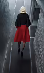 a woman in a red dress walks down a walkway