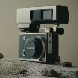 an analog camera sitting on top of a rock