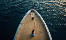 a person sitting in a boat that is at the pier