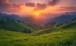 beautiful sunset above grassy hills and a distant valley