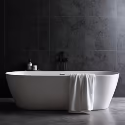 a white bathtub sitting under a gray wall