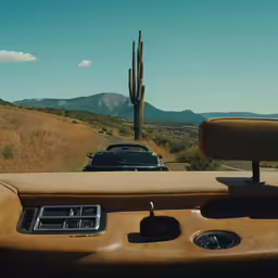 the dashboard and instrument screen of a vehicle driving along a desert road