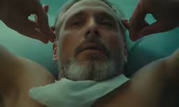 this is a man doing a haircut with a towel on his head