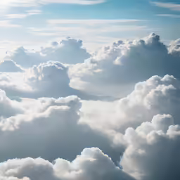 a large grouping of white clouds floating over a blue sky