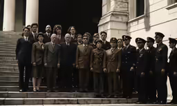 group of men and women dressed in suits on steps