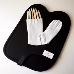 white gloves and a pair of gloves on top of a black case