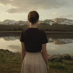 a woman in an outdoor scene looks at the water