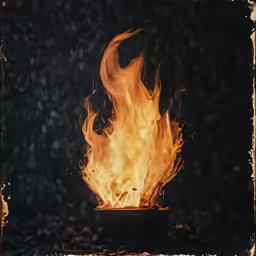 a fire blazing on a black background during the daytime