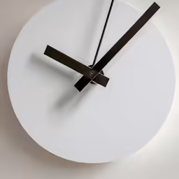 a white clock with a brown second hand on a beige surface