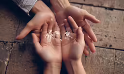 two people holding white flowers in their hands