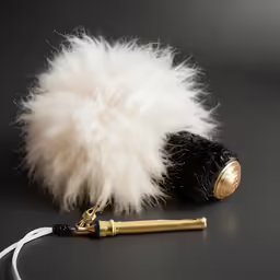 there is a ball of feather and a metal pen