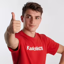 a young man poses with his thumb up in the air